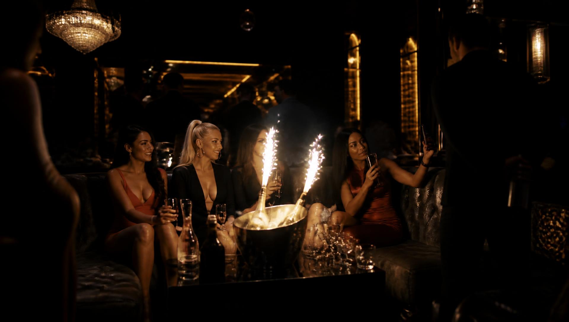 Guests celebrating with sparklers at a bottle service table